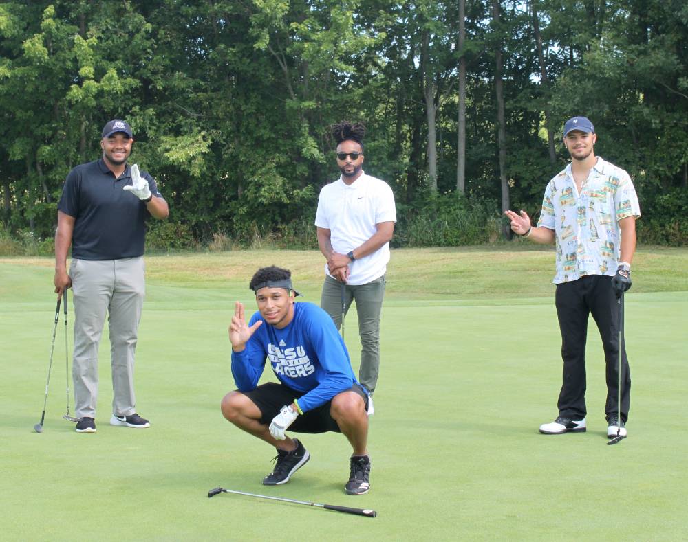 four lakers posing together on the golf course